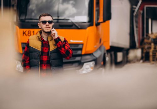 Handsome man truck driver standing by the truck